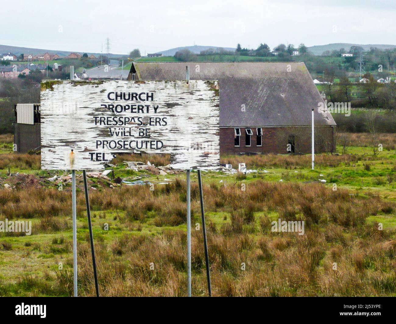 Sign outside a derelict church saying 'Church property.  Tresspassers (sic) will be prosecuted' Stock Photo