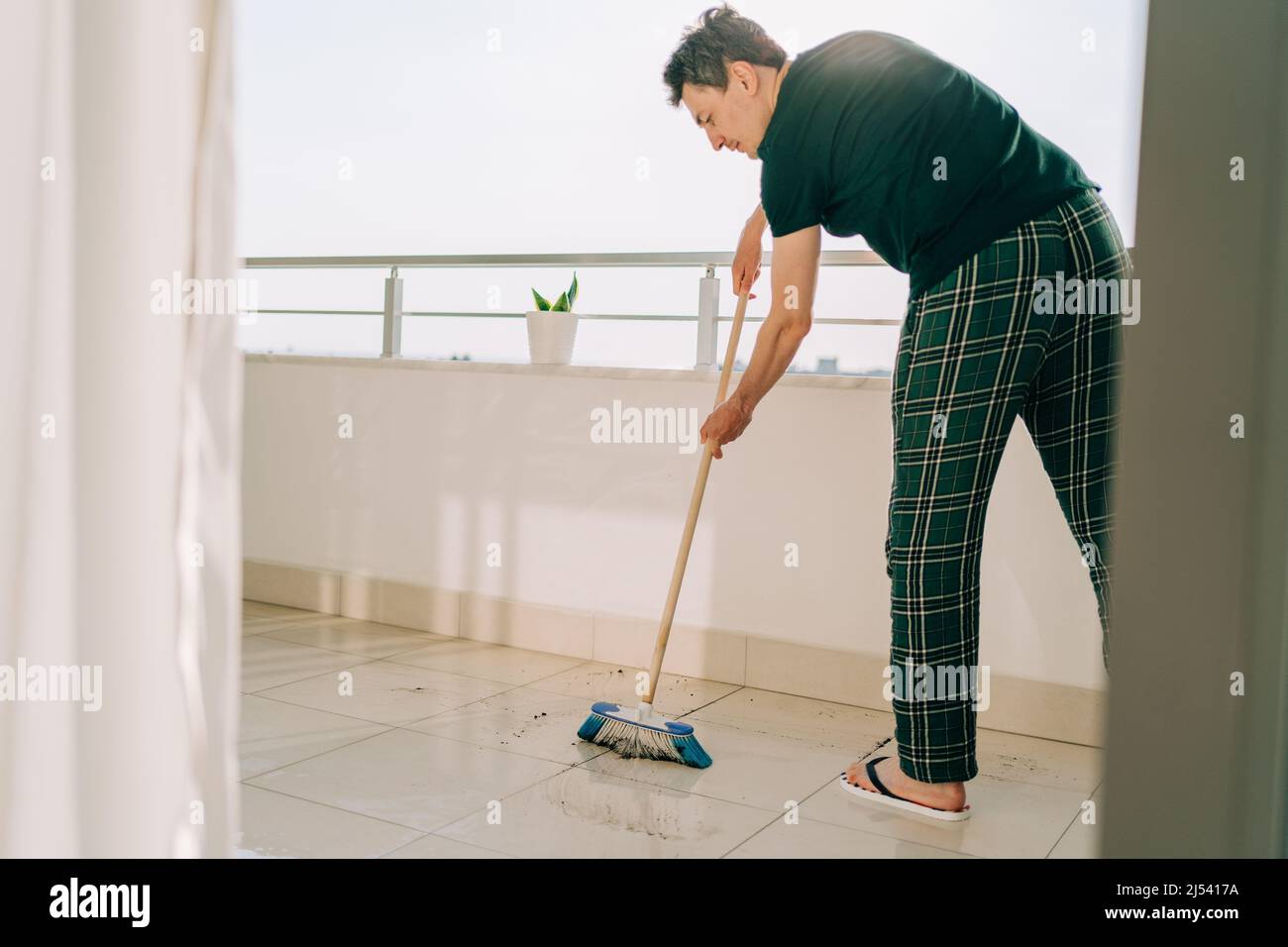 Man wiping floor with the mop. Janitor male washing the dirty floors