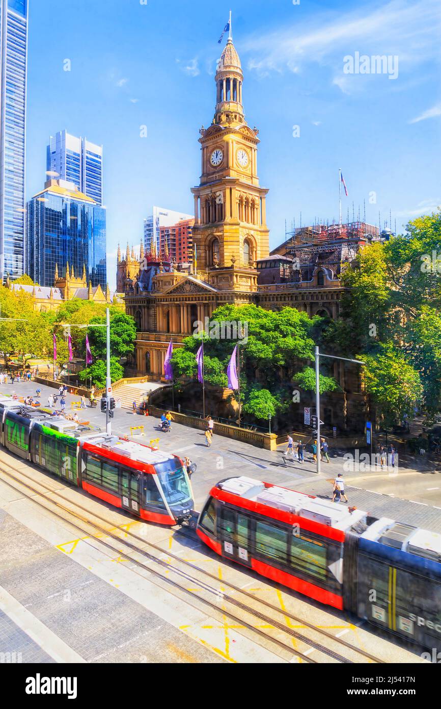 Public transport tram crossing george street square in front of Sydney Town Hall house. Stock Photo