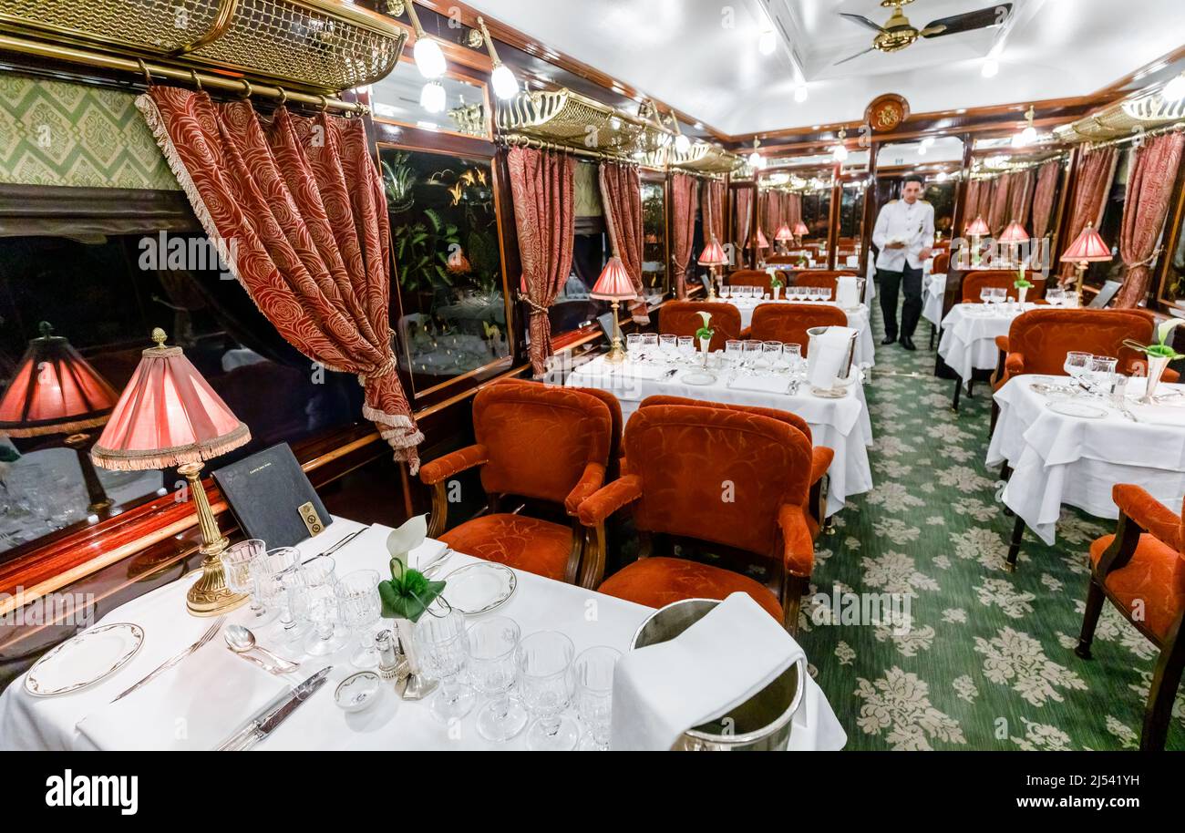 The interior of a luxurious dining car carriage on the Belmont Venice Simplon Orient Express with tables set for dinner Stock Photo