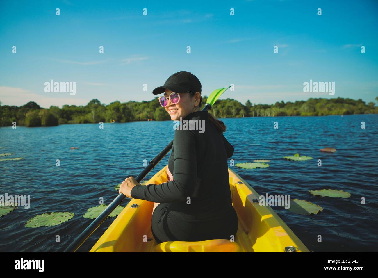 woman sailing sea kayak in fresh water lagoon rayong thailand Stock Photo