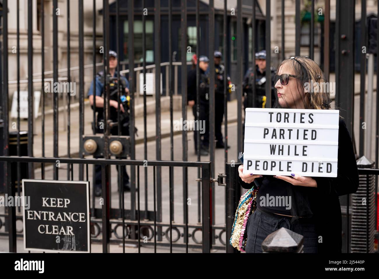 On the day that Prime Minister Boris Johnson apologised to parliament about his fixed-penalty fine for being present at a party during his own Covid pandemic restrictions, a protester holds a message at the gates of Downing Street, on 19th April 2022, in London, England. The Met police continue to investigate Johnson and his staff as news of more lockdown party fines are expected to be revealed by police. Stock Photo