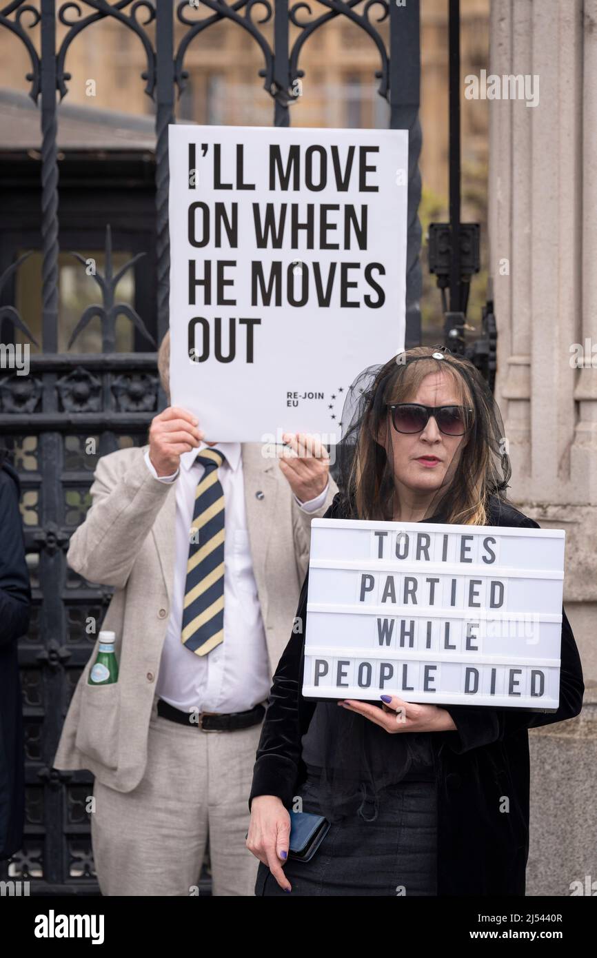 On the day that Prime Minister Boris Johnson apologised to parliament about his fixed-penalty fine for being present at a party during his own Covid pandemic restrictions, protesters hold placards at the gates of parliament, on 19th April 2022, in London, England. The Met police continue to investigate Johnson and his staff as news of more lockdown party fines are expected to be revealed by police. Stock Photo