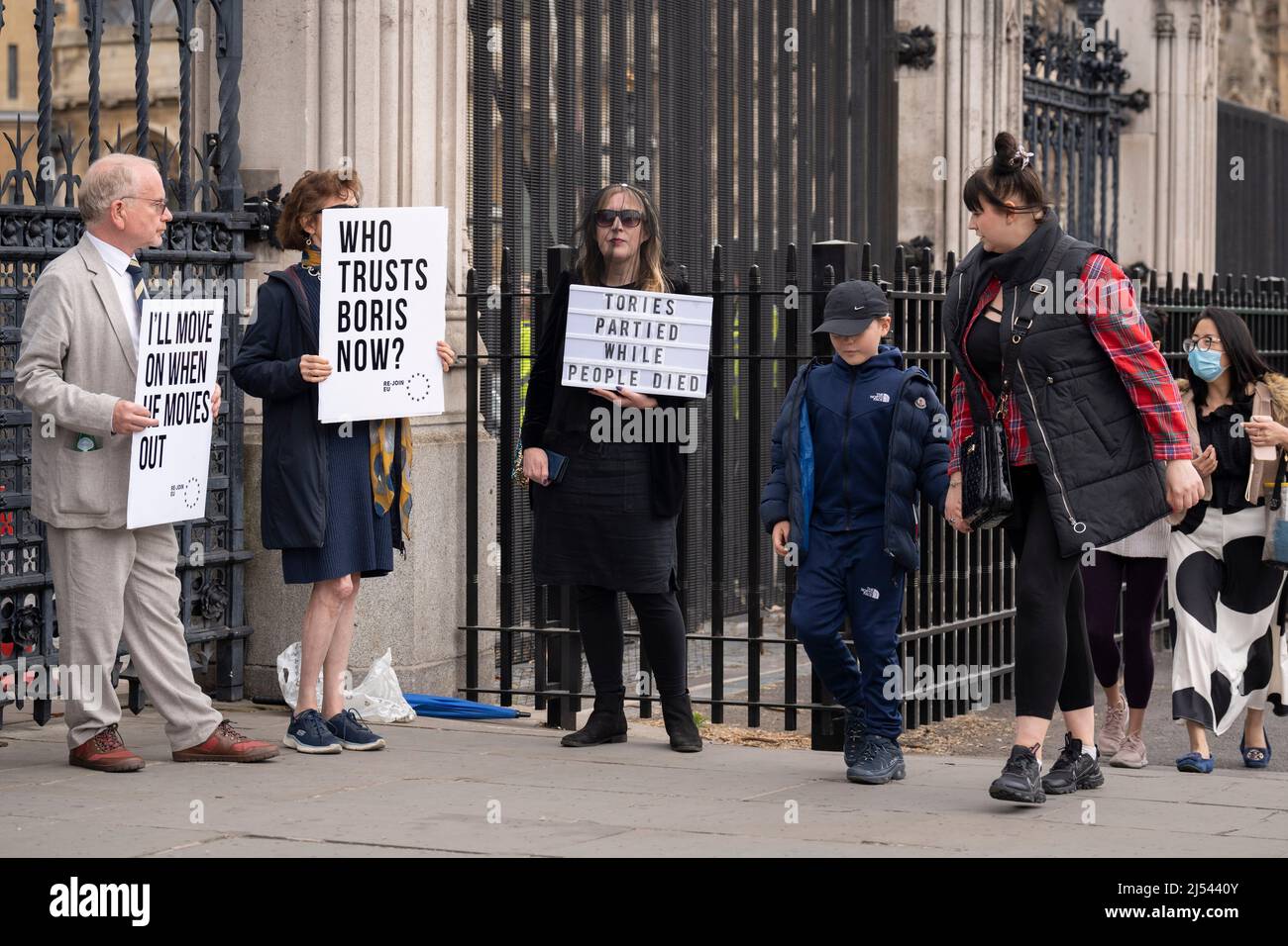On the day that Prime Minister Boris Johnson apologised to parliament about his fixed-penalty fine for being present at a party during his own Covid pandemic restrictions, protesters hold placards at the gates of parliament, on 19th April 2022, in London, England. The Met police continue to investigate Johnson and his staff as news of more lockdown party fines are expected to be revealed by police. Stock Photo