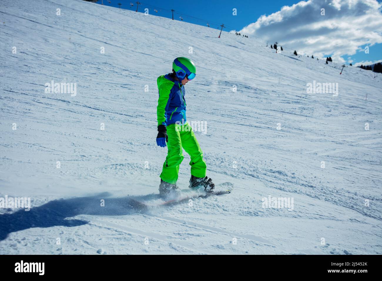 Boy on snowboard in full snowboarder outfit go fast downhill Stock Photo
