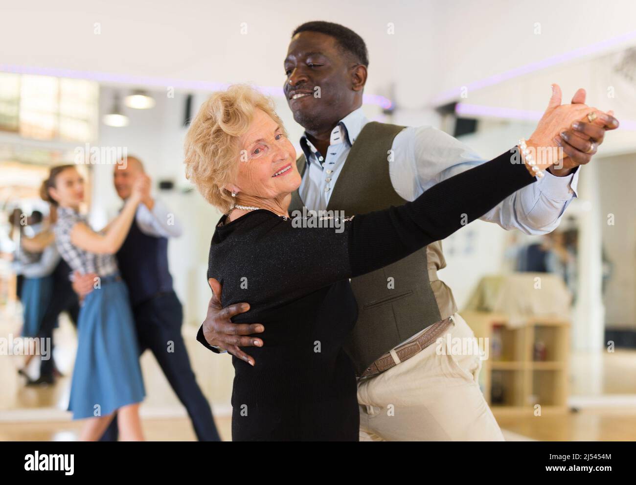 Elderly woman learning ballroom dancing in pair in dance studio Stock ...
