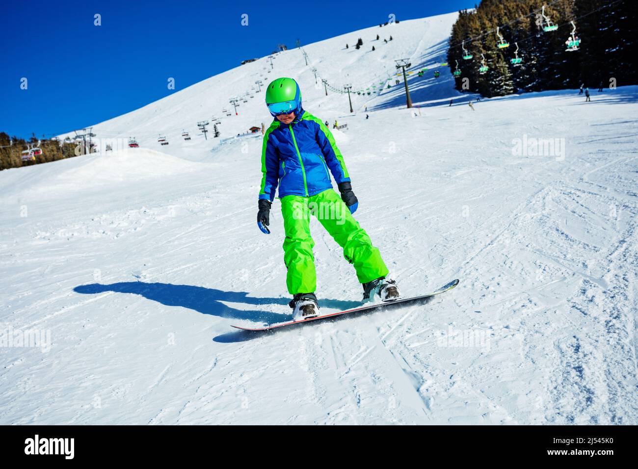 Action photo of a snowboarder boy in motion on ski slope Stock Photo