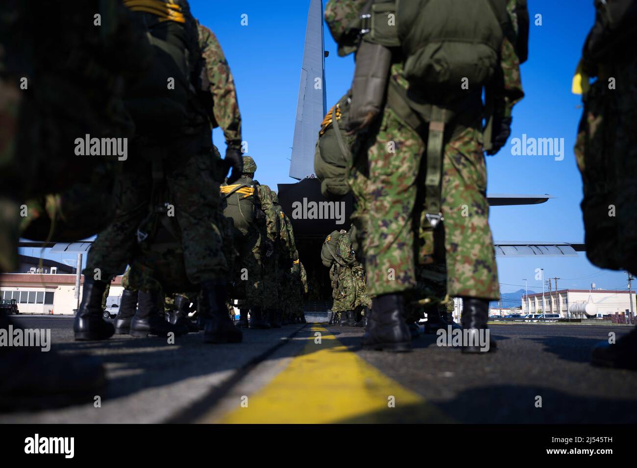 Japan Ground Self-Defense Force 1st Airborne Brigade soldiers line up on the flightline at Yokota Air Base, Japan, during a bilateral jump training with the 36th Airlift Squadron, April 19, 2022. The goal of this event is to improve interoperability between the USAF and JGSDF by defense and information exchanges to deepen mutual understanding of each unit, and to further cement the U.S. and Japanese alliance. (U.S. Air Force photo by Tech. Sgt. Gustavo Castillo) Stock Photo