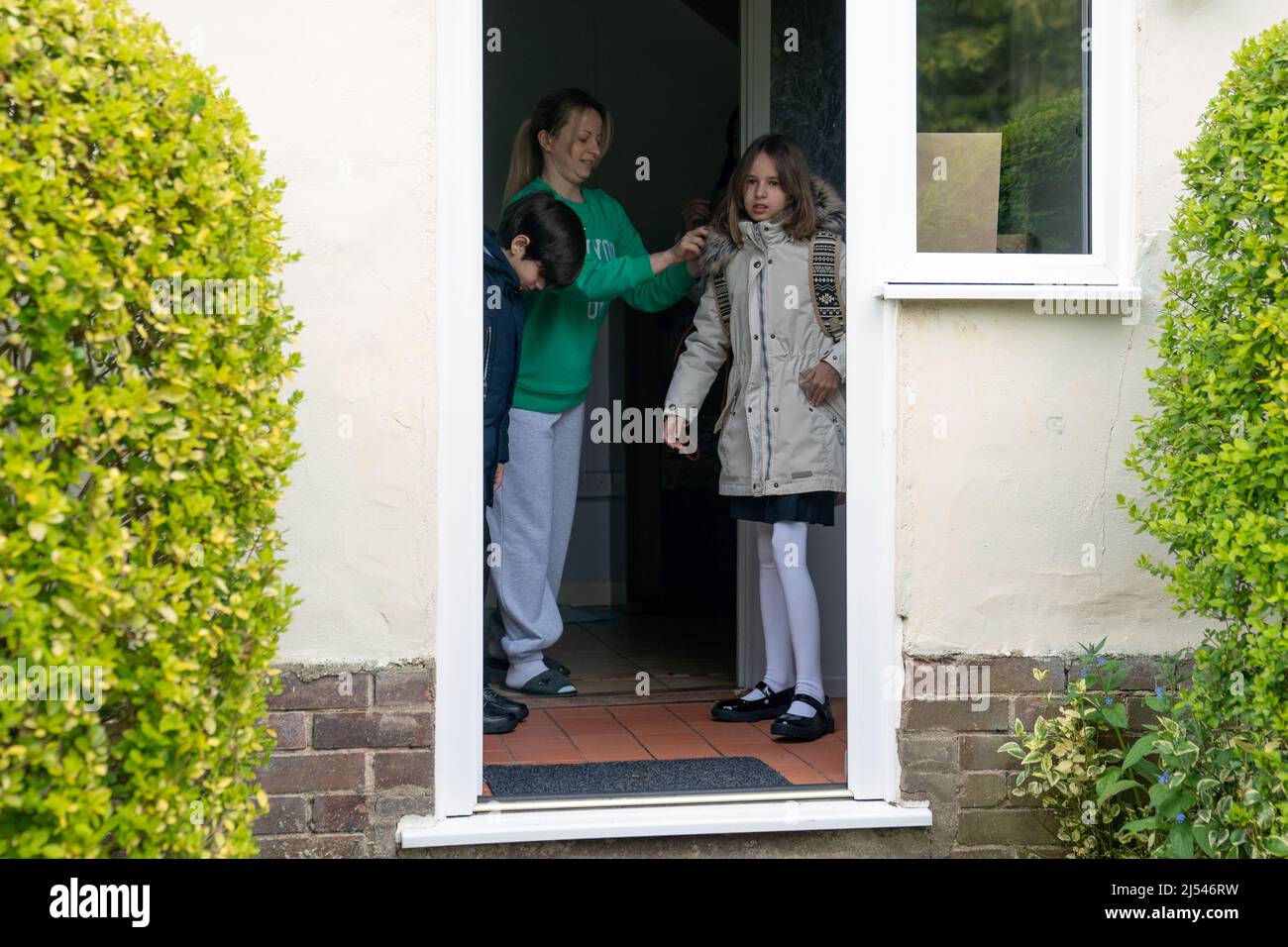 Ukrainian refugees Alikhan Yusupov, 10, and Miroslava Starkova, 11, before walking to Caldecote Primary School for their first day of classes since they fled their home in Kharkiv, Ukraine and moved to the village of Caldecote in Cambridgeshire. Picture date: Wednesday April 20, 2022. Stock Photo
