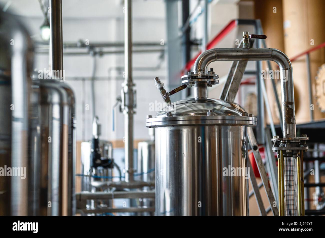 Stainless tanks with pipelines installed in processing shop Stock Photo