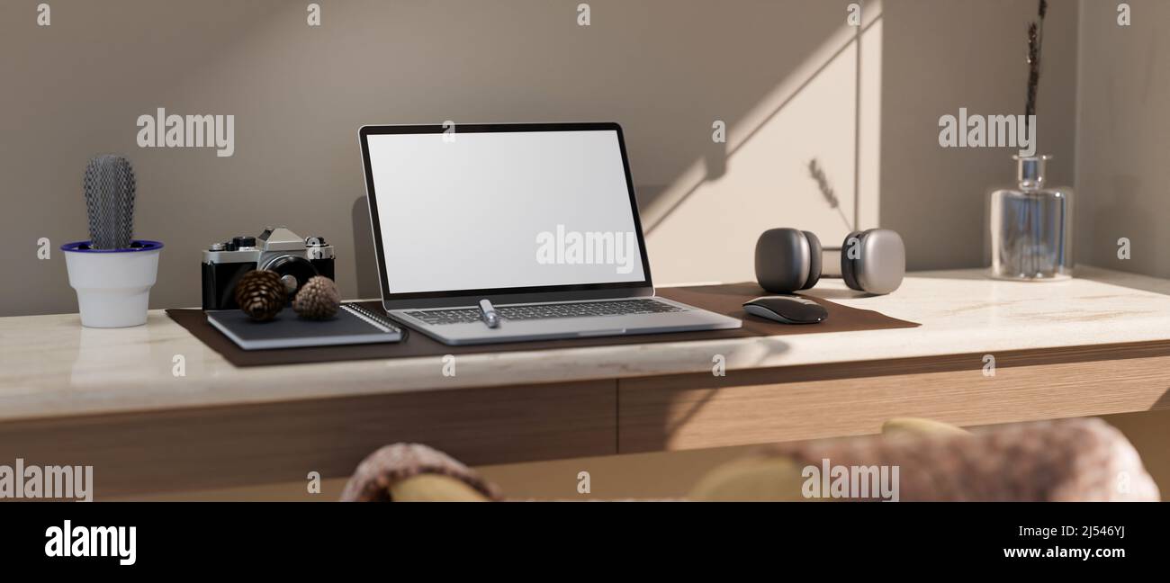 Modern workspace studio with the daylights through the window, open laptop white screen mockup, retro camera, headphone and accessories on table. 3d r Stock Photo
