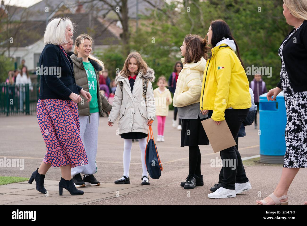 Ukrainian refugee Miroslava Starkova, 11, arrives at Caldecote Primary School with her mother Halyna (second left) for her first day of classes since they fled their home in Kharkiv, Ukraine and moved to the village of Caldecote in Cambridgeshire. Picture date: Wednesday April 20, 2022. Stock Photo
