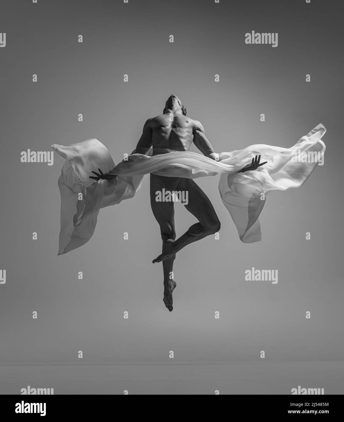 Black and white portrait of graceful muscled male ballet dancer dancing