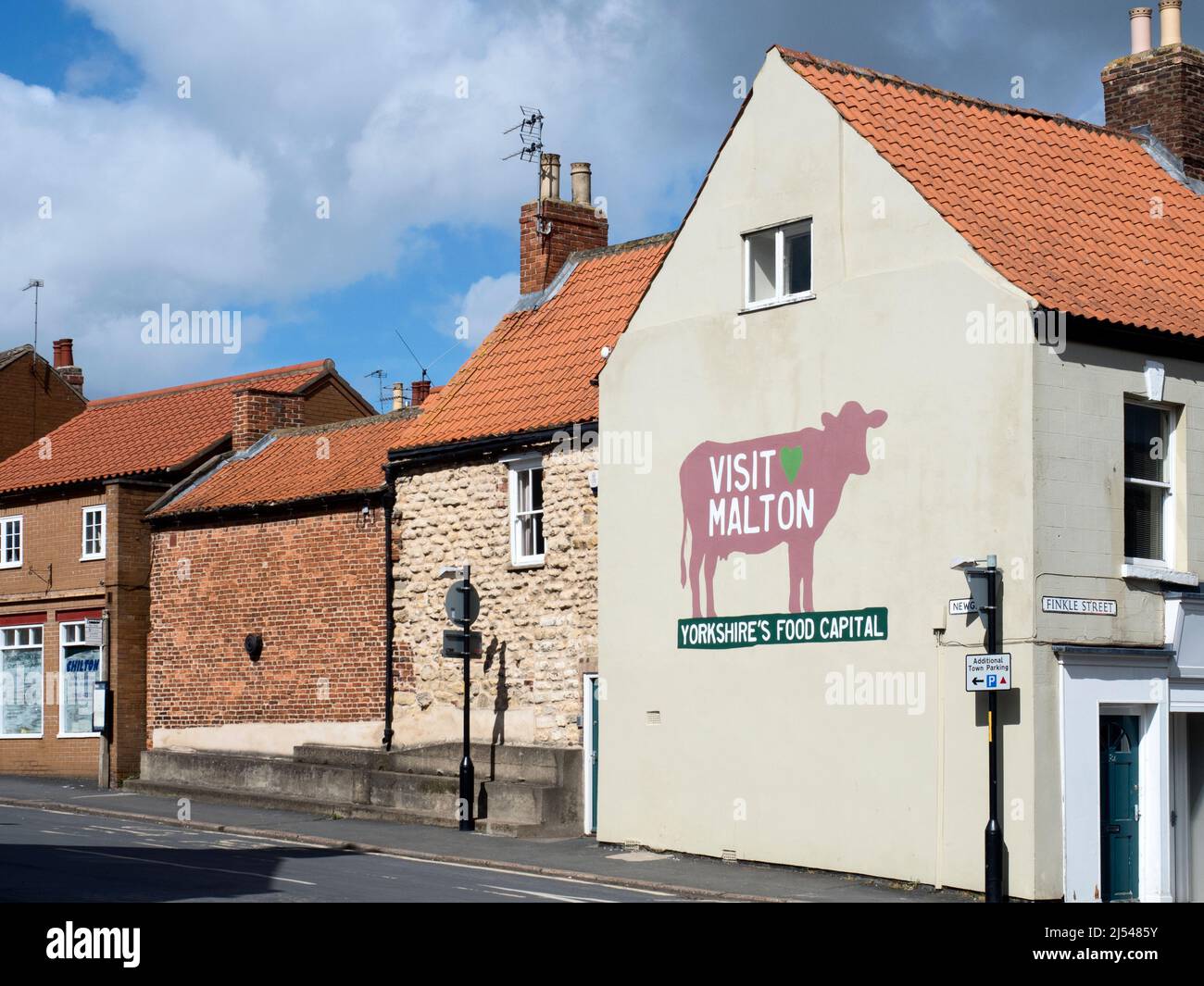 Visit Malton Yorkshires Food Capital sign on the corner of Newgate and Finkle Street in Malton North Yorkshire England Stock Photo