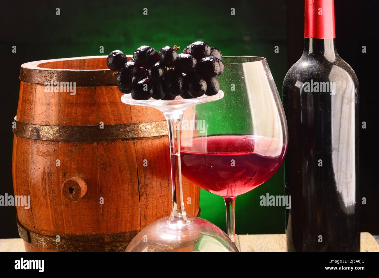 Still life with glasses and bottle of wine ,barrel nerb.background:green gradient. Stock Photo