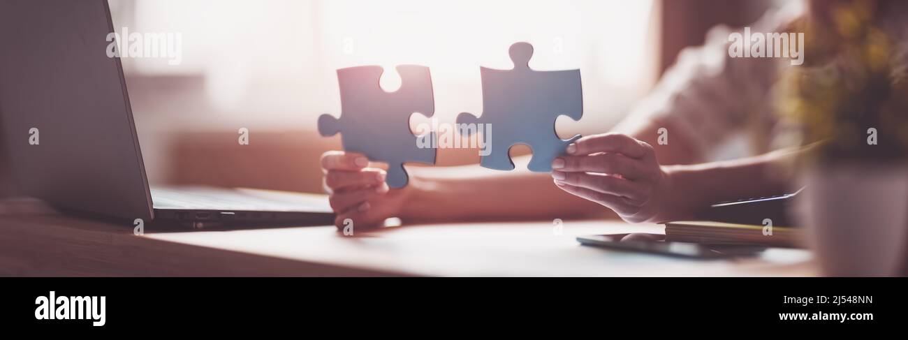 Woman holding pieces of puzzle in the office Stock Photo