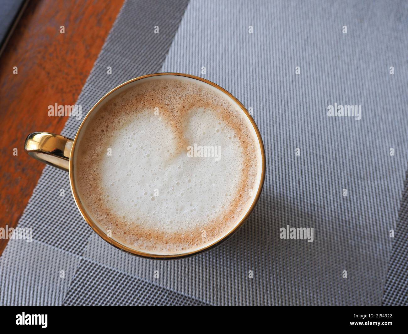 Close-up of a mug of coffee seen from above showing latte art in the shape of a heart Stock Photo