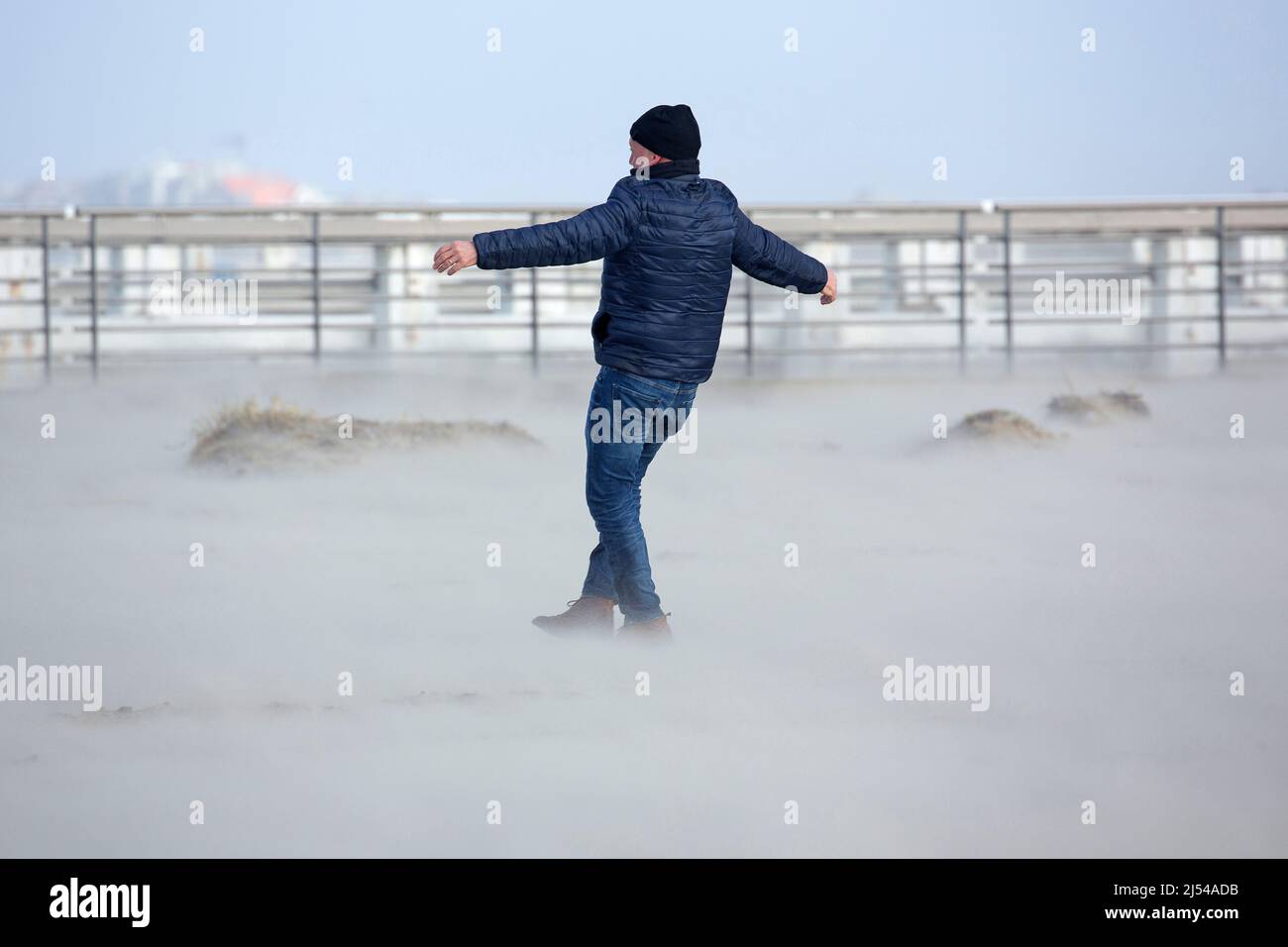 walker in the storm on the sandy beach, Hurricane Eunice, Zeynep, 02/19/2022, Belgium, West Flanders, Nieuwpoort Stock Photo