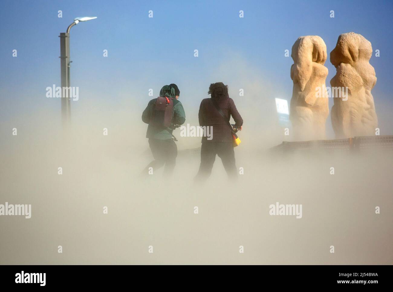 walkers in the storm on the sandy beach, Hurricane Eunice, Zeynep, 02/19/2022, Belgium, West Flanders, Nieuwpoort Stock Photo