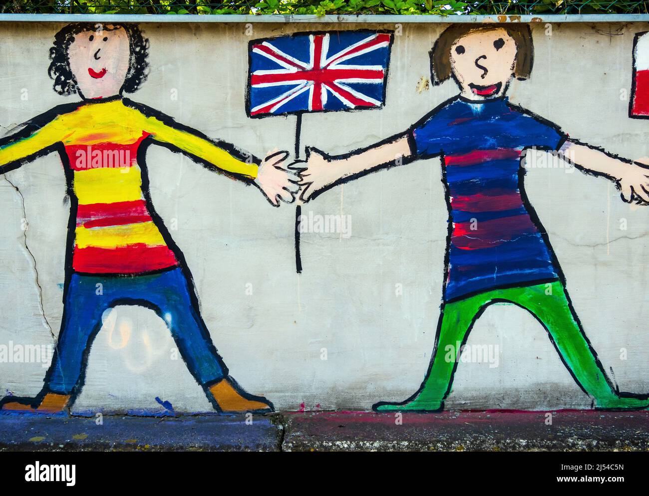 children hold British flag, graffiti on a wall Stock Photo