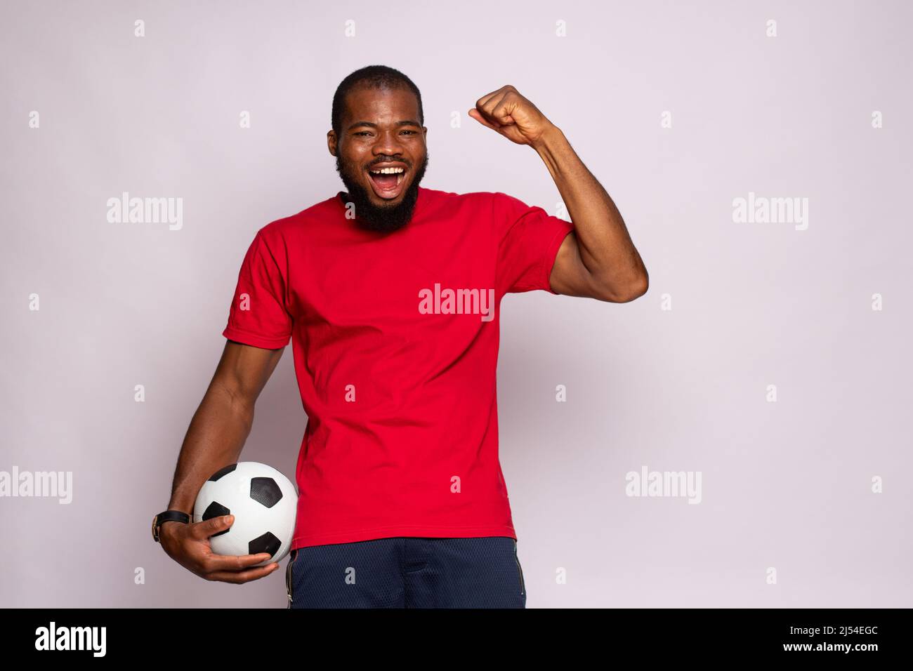 african man holding a soccer ball celebrates Stock Photo - Alamy