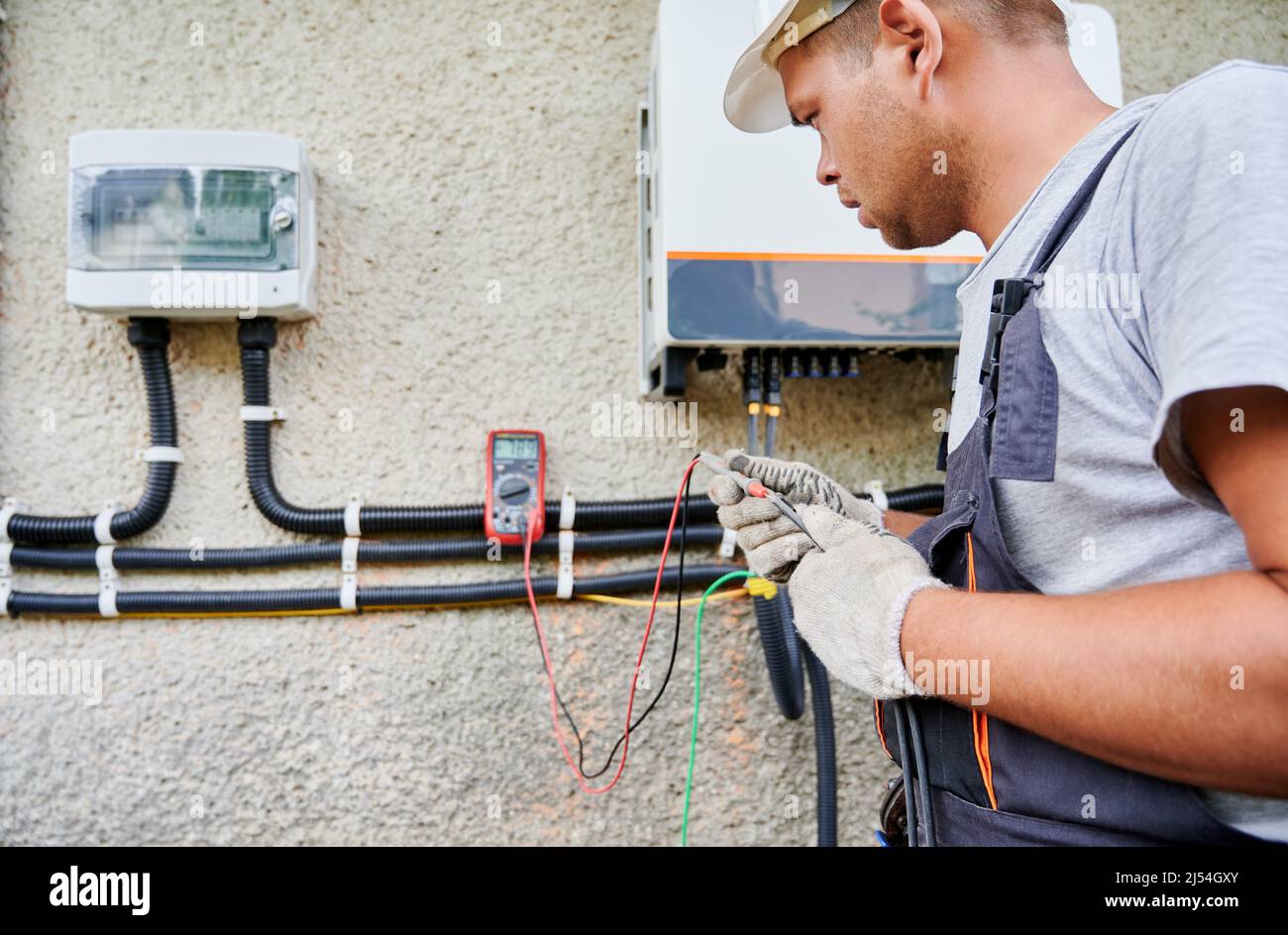 Man electrician installing solar panel system. Inspector in gloves making  electrical wiring inverter and electric box. Concept of alternative and  renewable energy Stock Photo - Alamy