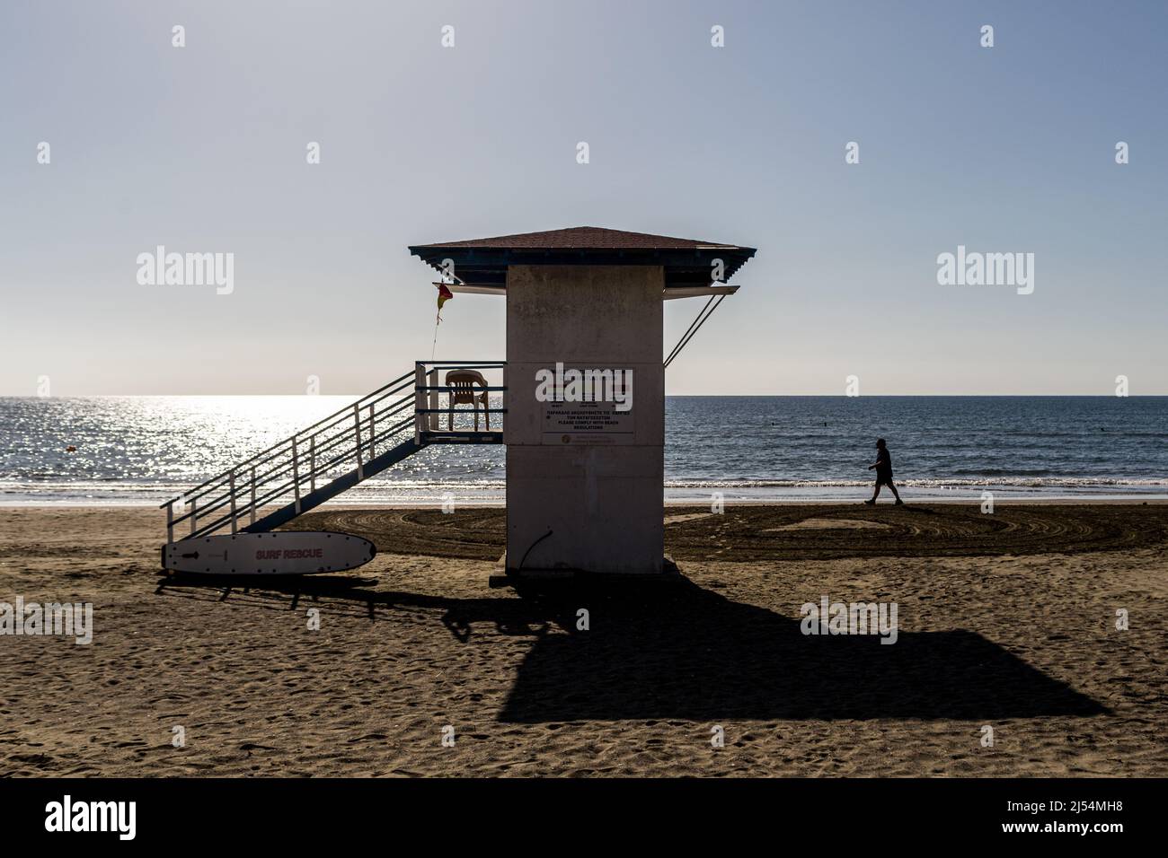 Larnaca, Cyprus. 20th Apr, 2022. A man walks by a lifeguard tower in Mackenzie Beach, Larnaca, Cyprus, on Apr. 20, 2022. The government of Cyprus is considering approaching new tourist markets in order to cover the gap left in the tourist industry by the situation in Ukraine. The Russian and Ukrainian tourists form up to 25% of the Cypriot tourist market. (Photo by Kostas Pikoulas/Sipa USA). Credit: Sipa USA/Alamy Live News Stock Photo