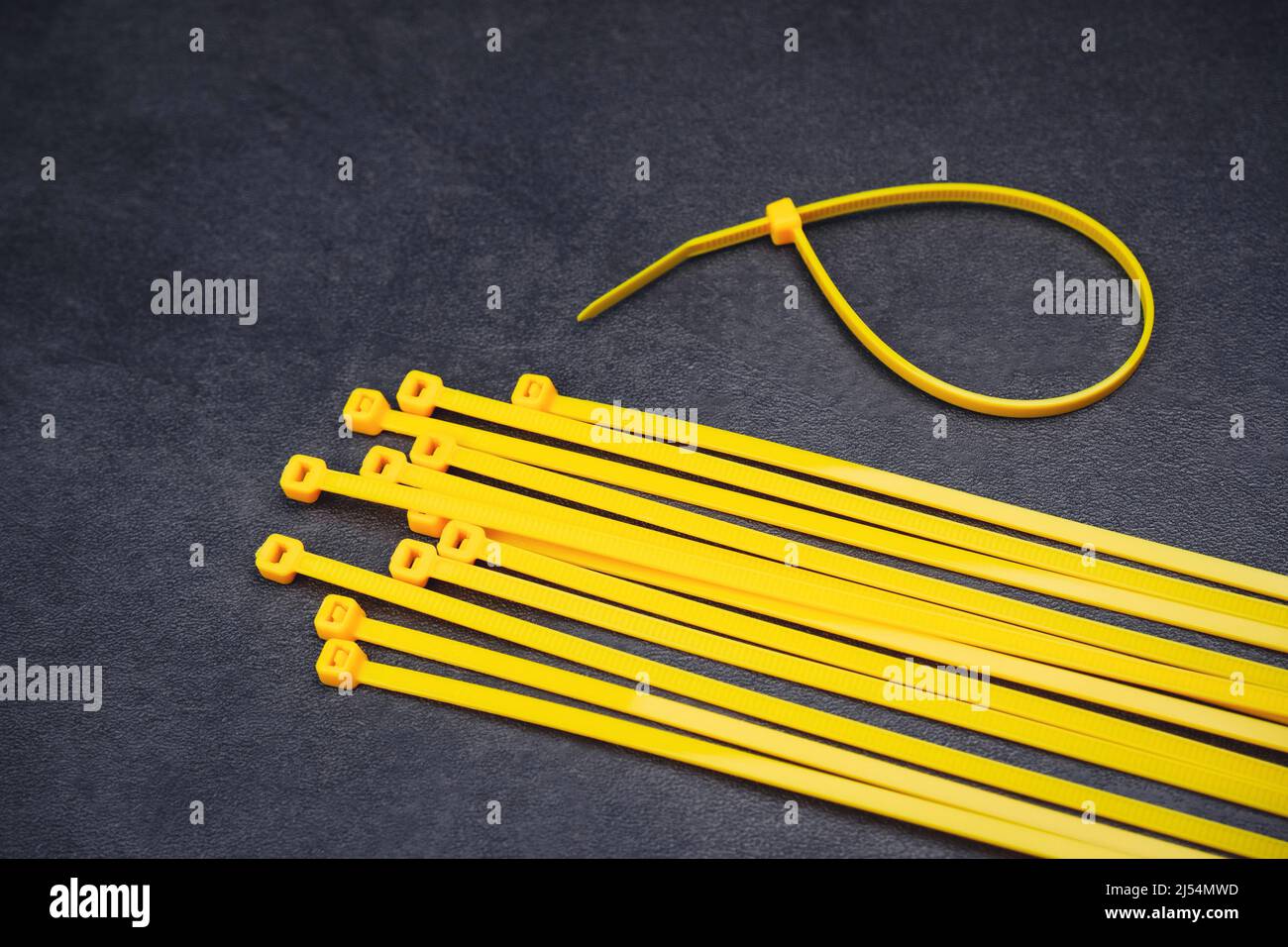 Yellow cable tie on the cement floor background Stock Photo