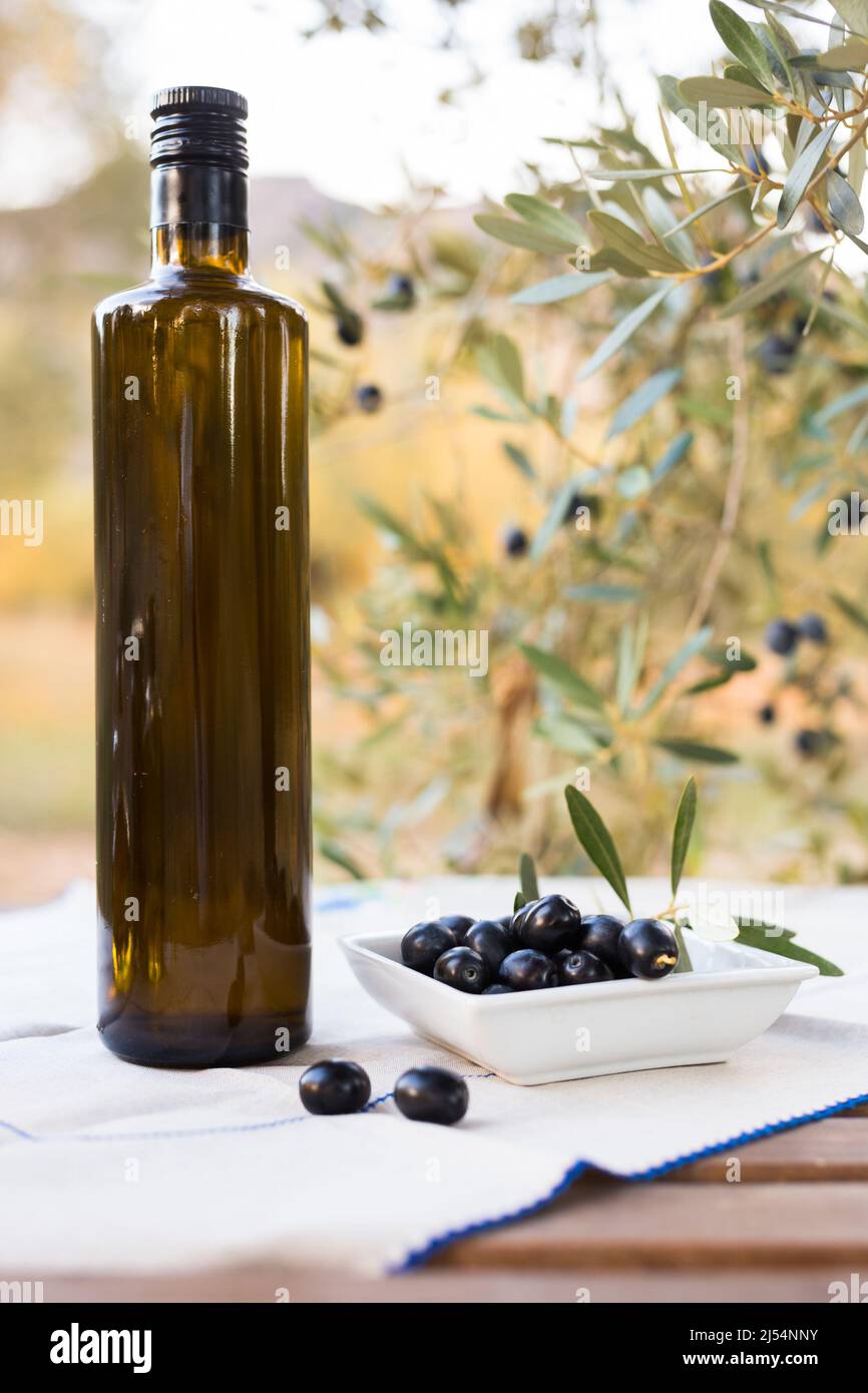 still life of olives and oil on a table against a background of olive