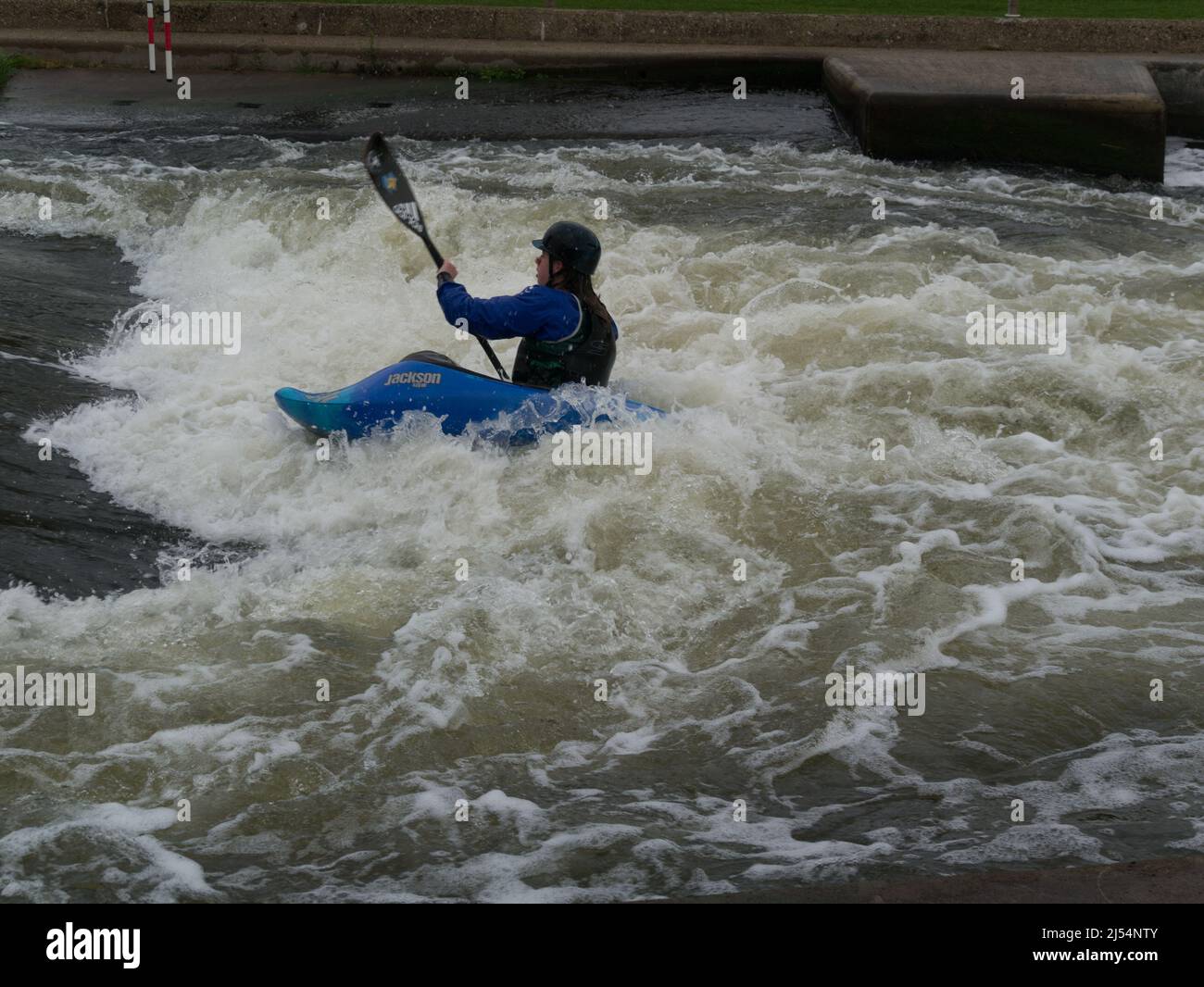 Young girl in Jackson Kayak tackling white water of Holme Pierrepont Country Park Nottingham England UK paddling against current National Watersports Stock Photo