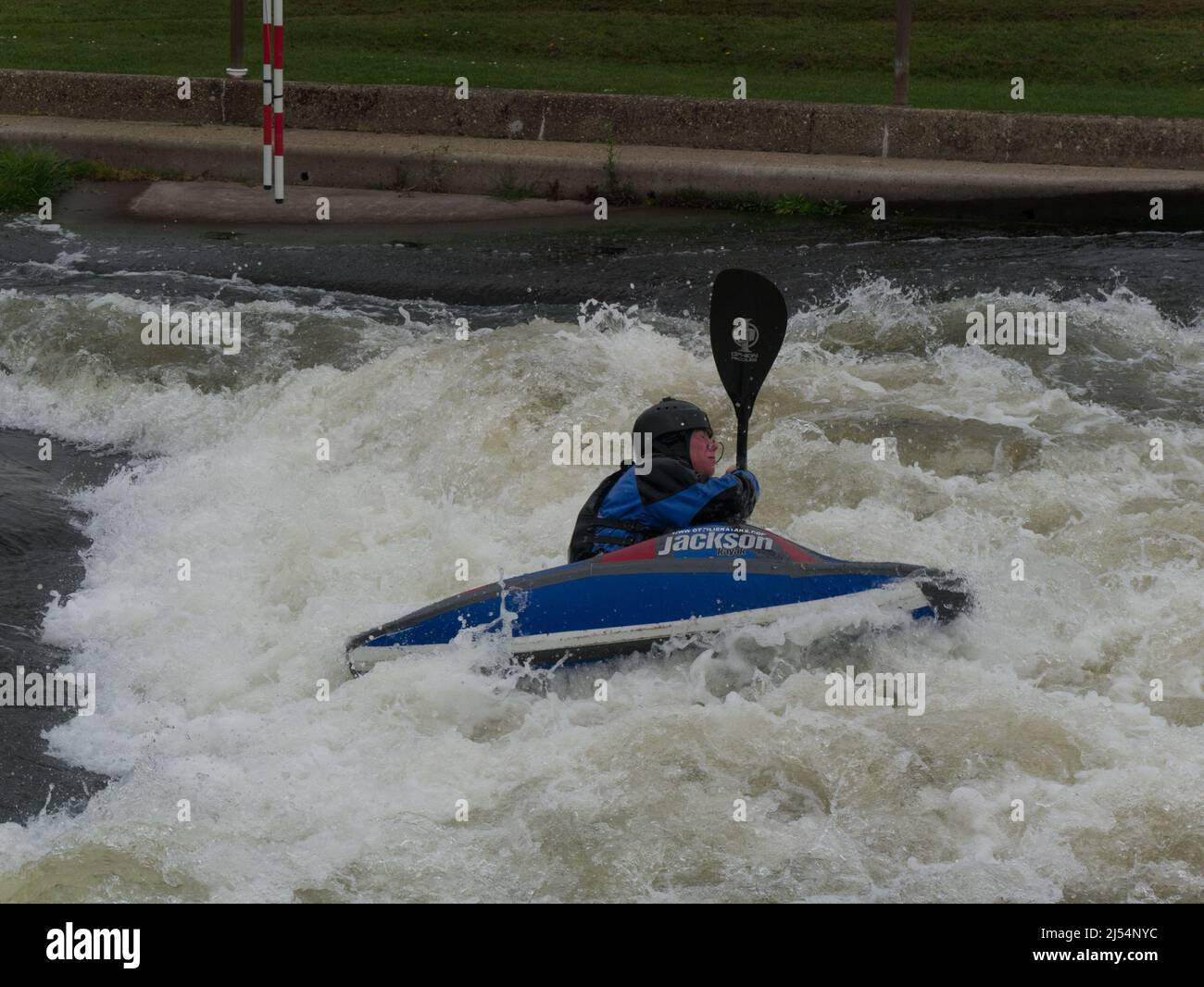 Young boy in Jackson kayak tackling white water of Holme Pierrepont Country Park Nottingham England UK paddling against current National Water Sports Stock Photo
