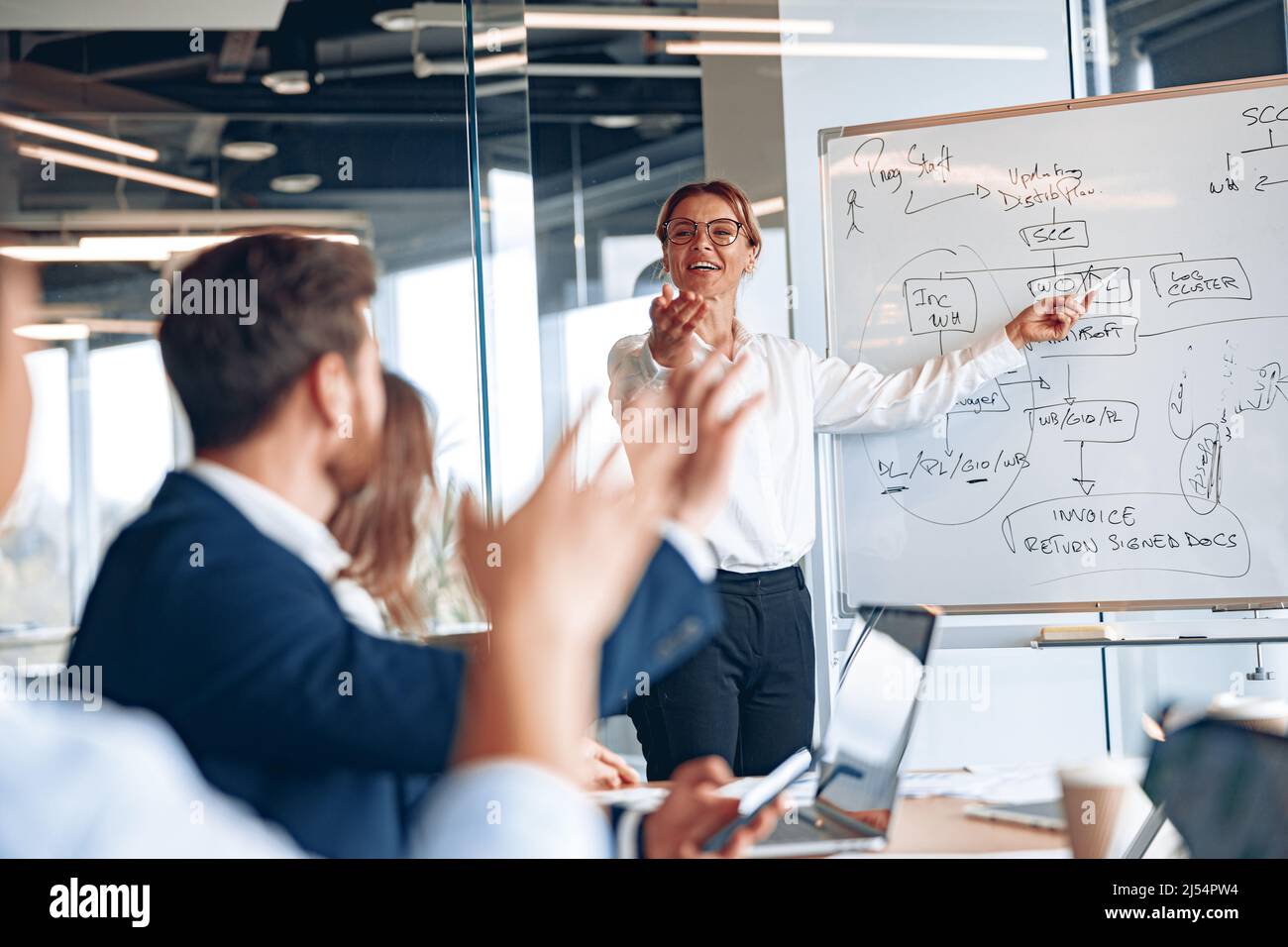 Experienced businesswoman by whiteboard explaining situation on the ...