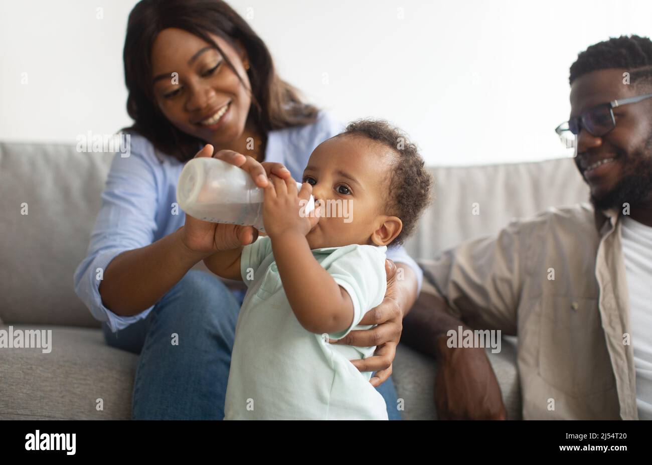 African American man feeding baby son bottle Stock Photo - Alamy