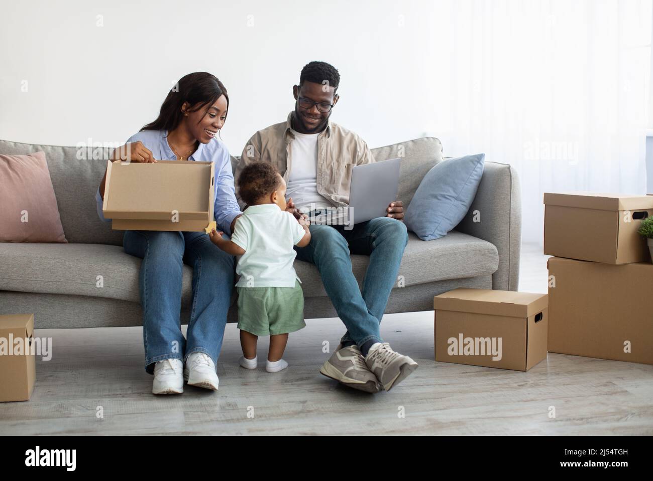 Happy man woman and kid using pc after relocation Stock Photo - Alamy