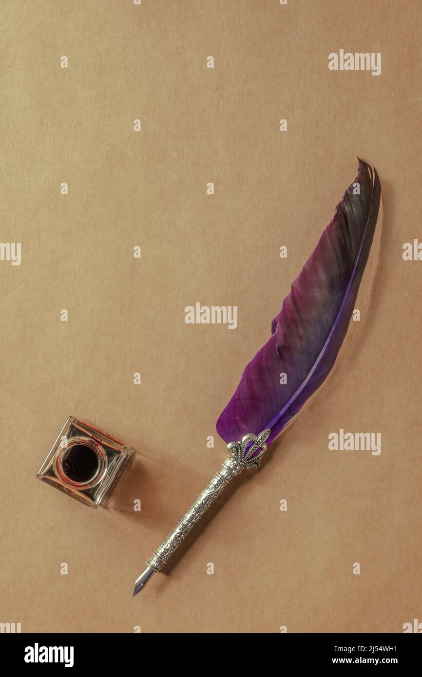 Feather quill pen with a vintage ink well, overhead flat lay shot on ...