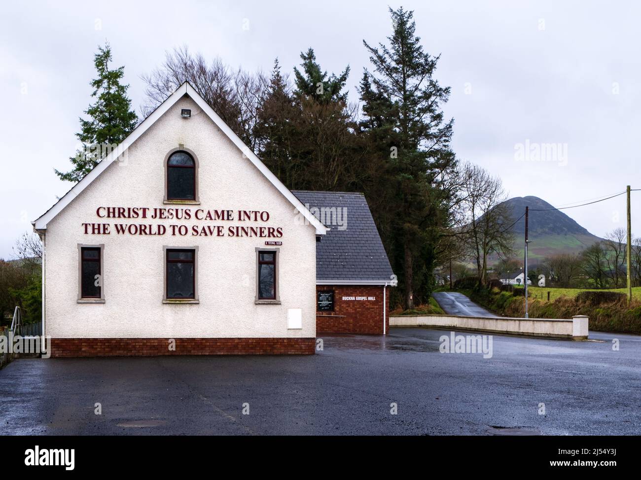 Buckna Gospel Hall in County Antrim with Slemish mountain in the background. Sign on the Gospel Hall reads 'Christ Jesus Came Into the World to Save S Stock Photo
