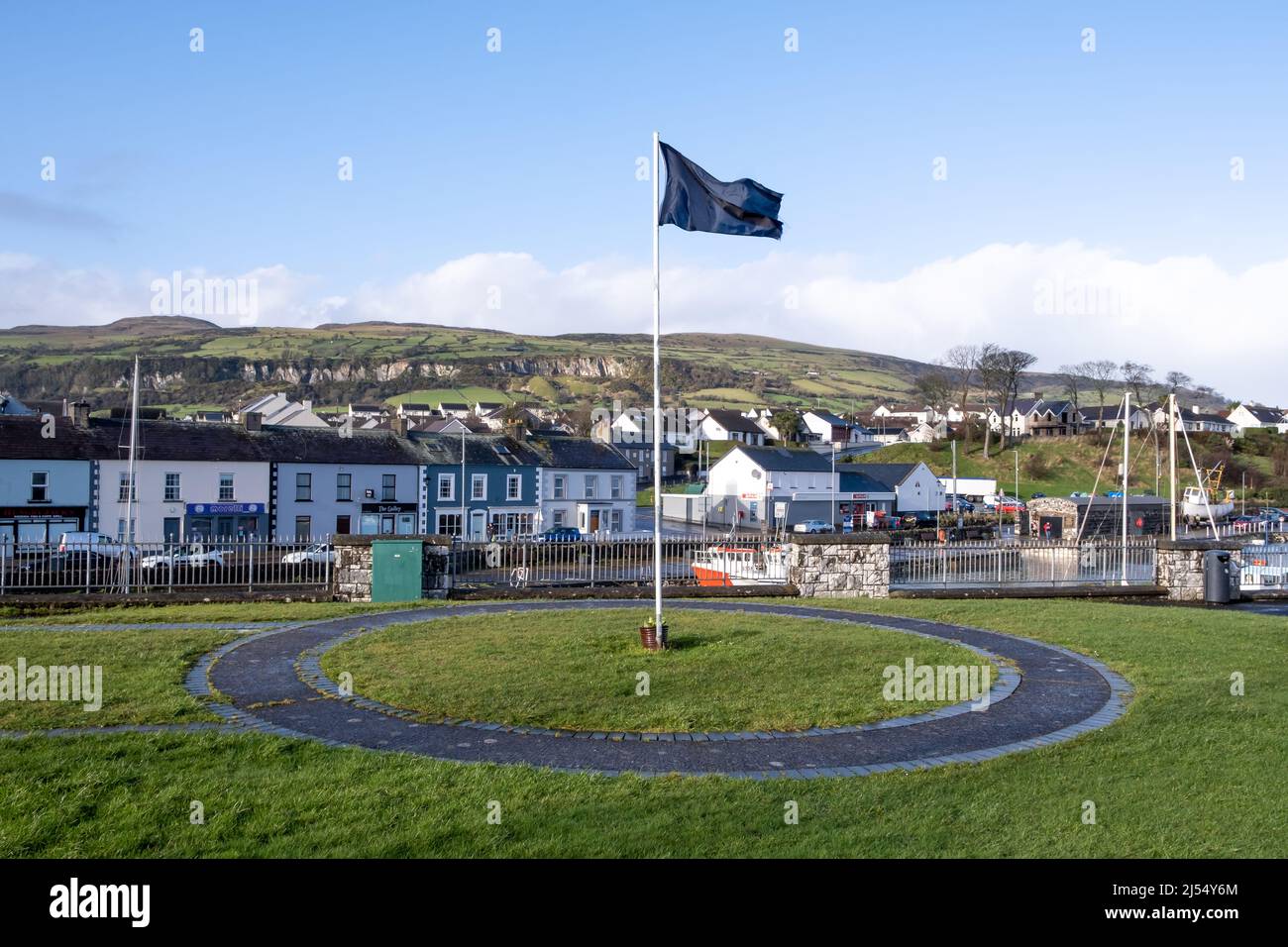 Black flag flying over the harbour in the Northern Ireland coastal town of Carnlough, County Antrim. Stock Photo