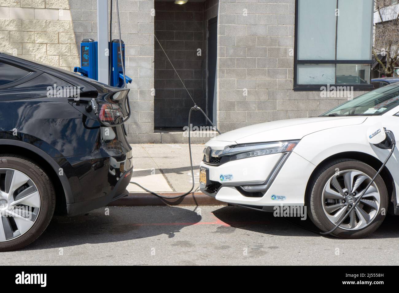 Two electric cars charges their batteries at a FLO charging station in