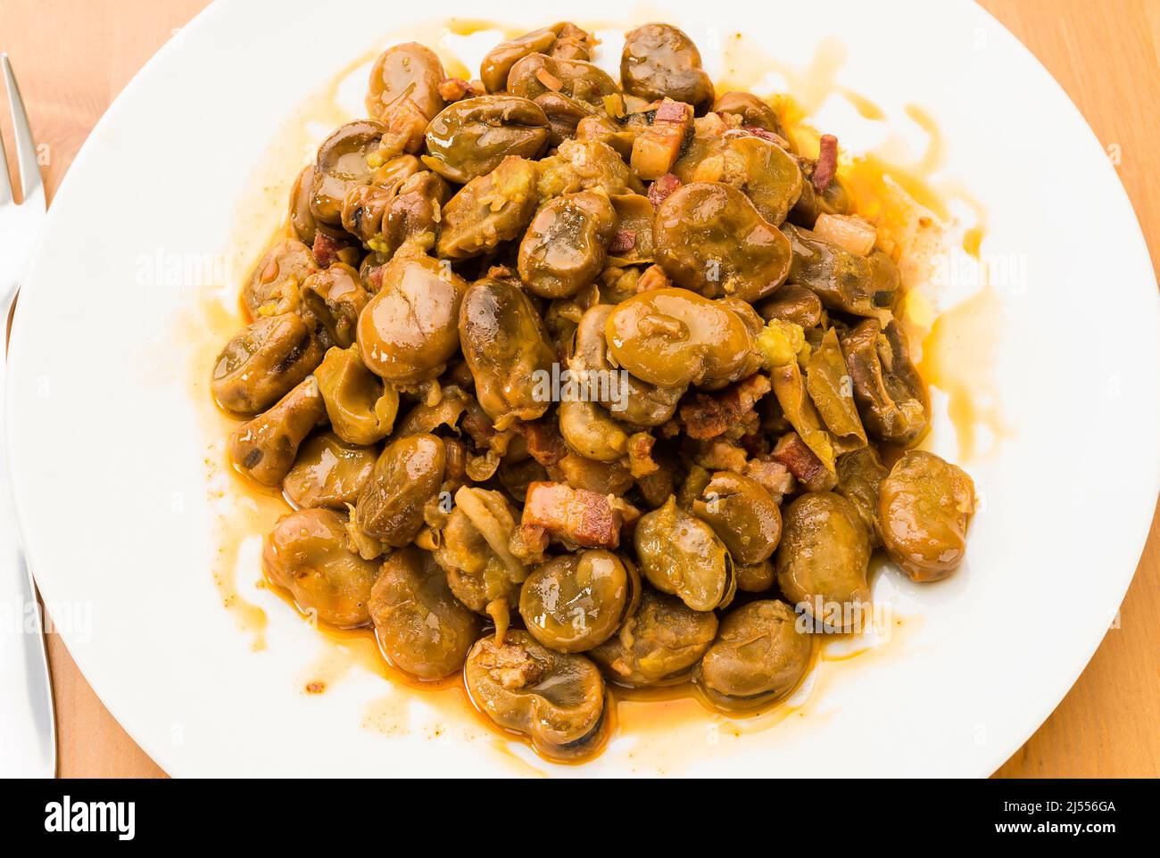 Typical Spanish food, tender broad beans with ham Stock Photo Alamy