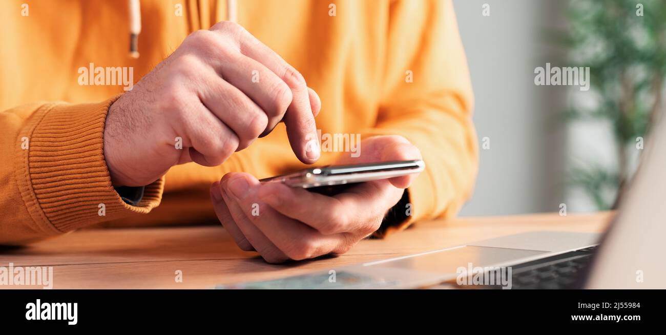 Closeup of male hands using mobile smart phone at home office desk, selective focus Stock Photo