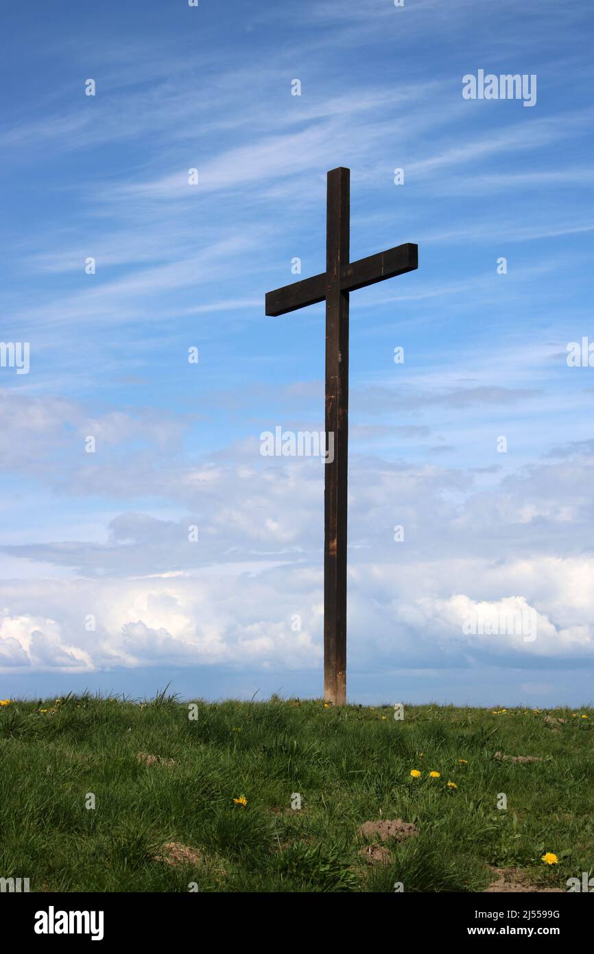 Wooden Easter Cross at Lane Ends Amenity Area, Pilling, Lancashirewith blue sky and white wispy clouds behind. Stock Photo