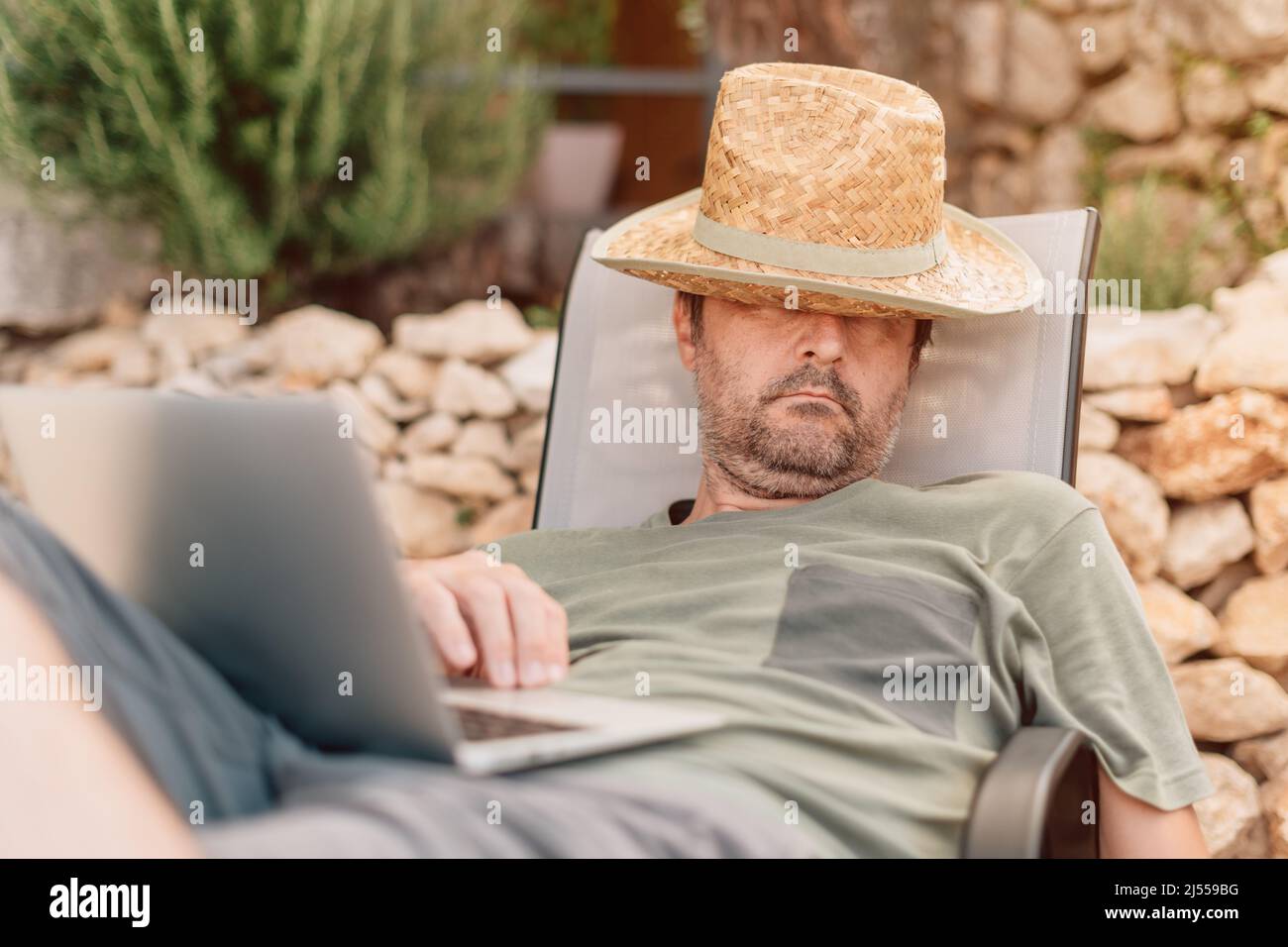Relaxed sleepy freelancer and digital nomad working on laptop computer ...