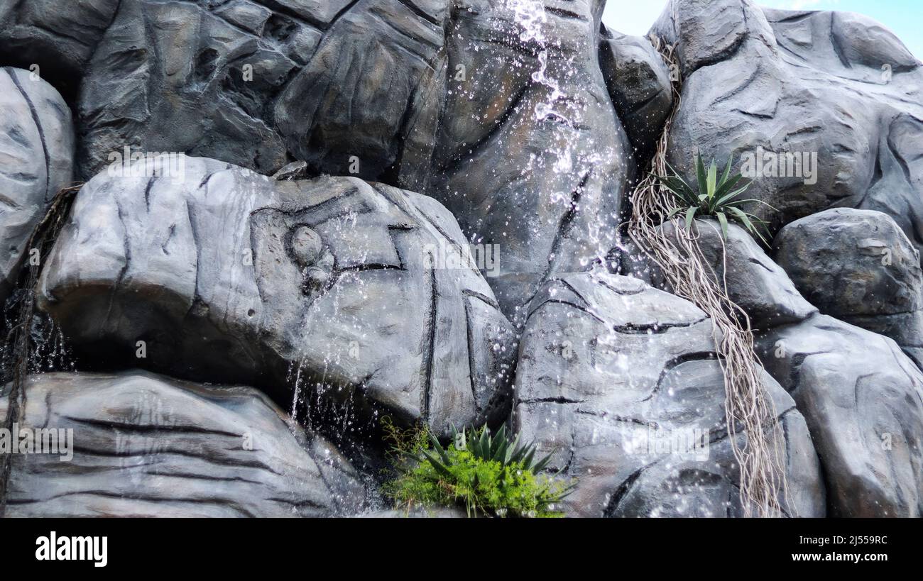 The artificial rock is poured into the water Stock Photo