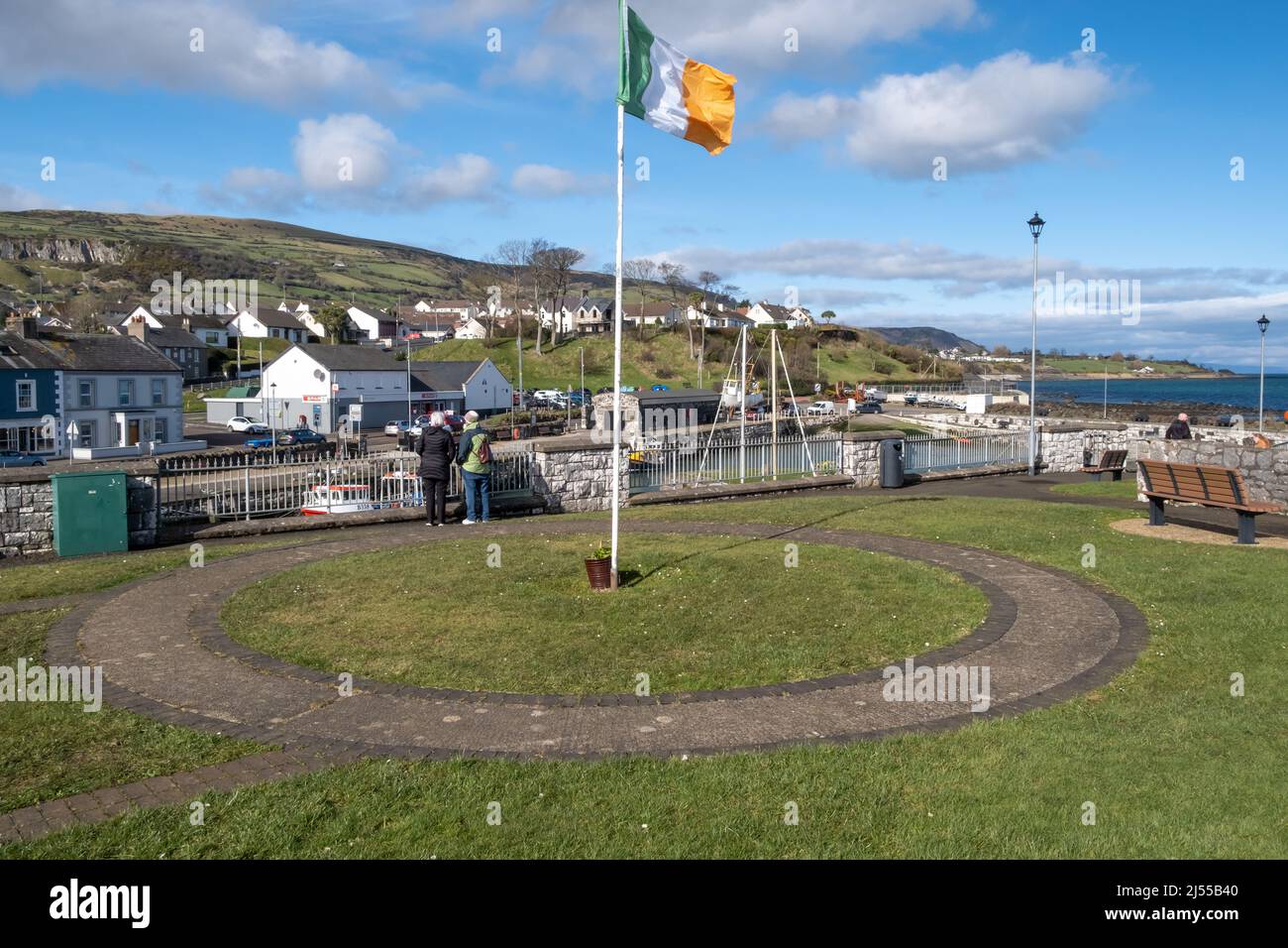 Irish Tricolour flying above the harbour at the North Antrim coastal town of Carnlough Stock Photo