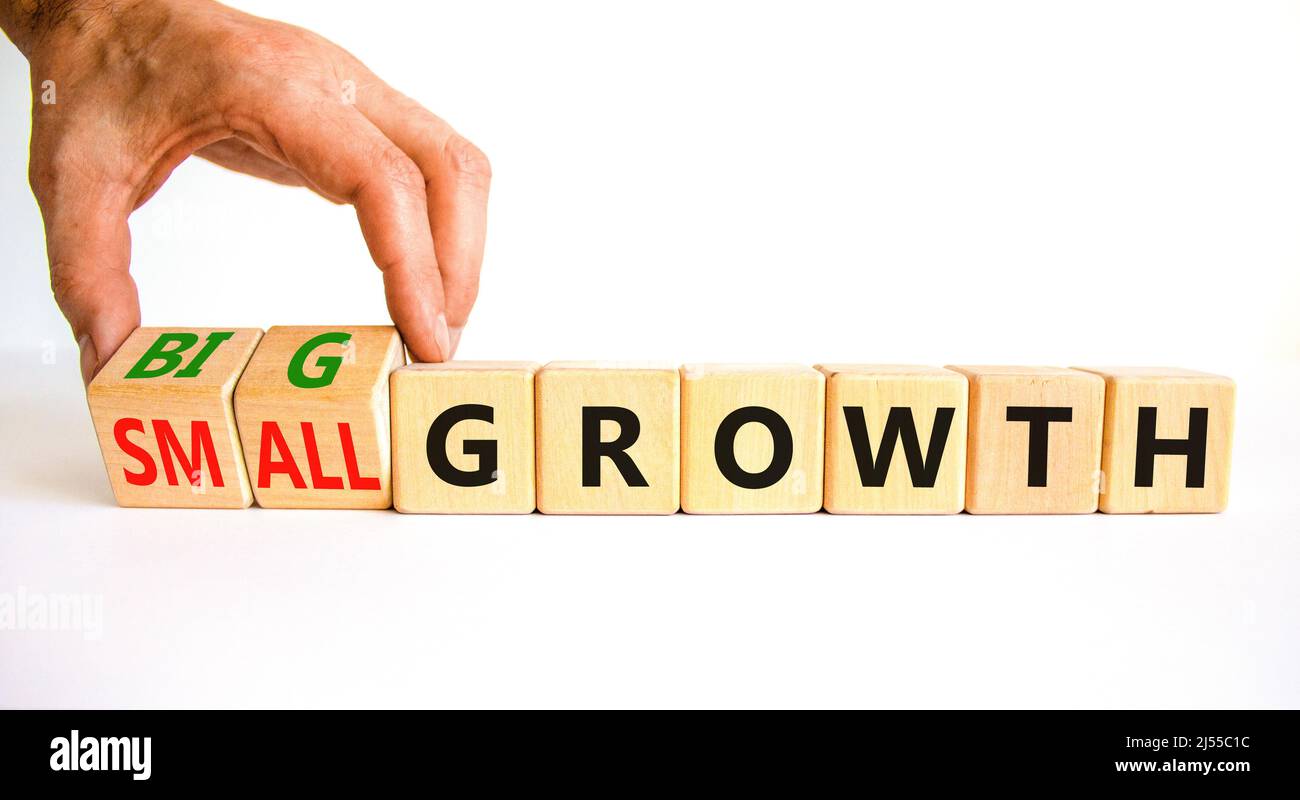 Big or small growth symbol. Businessman turns wooden cubes and changes