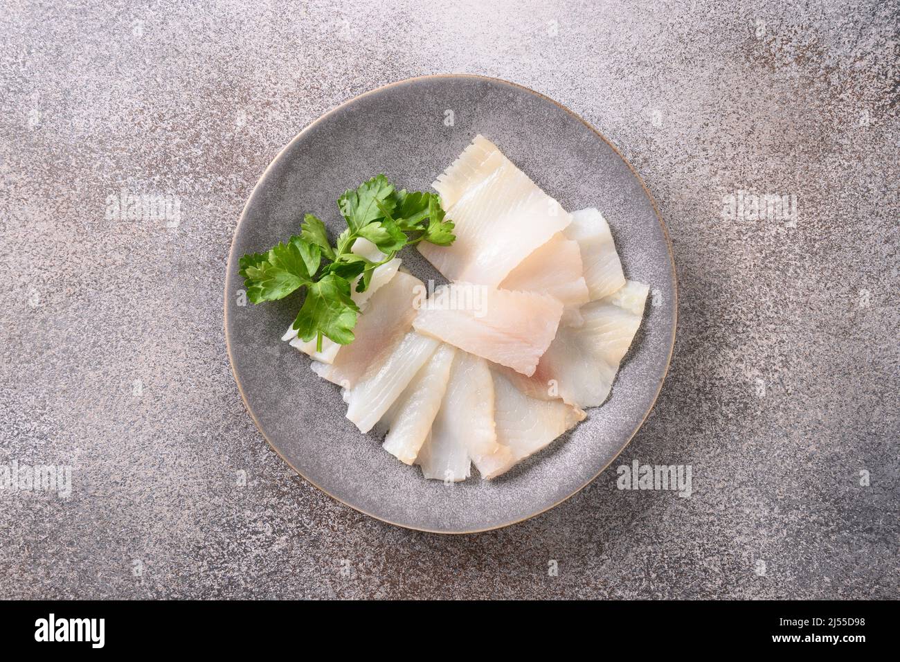 Delicious smoked halibut slices served in white plate isolated on gray background. Top view. Healthy omega 3 unsaturated fats. Stock Photo