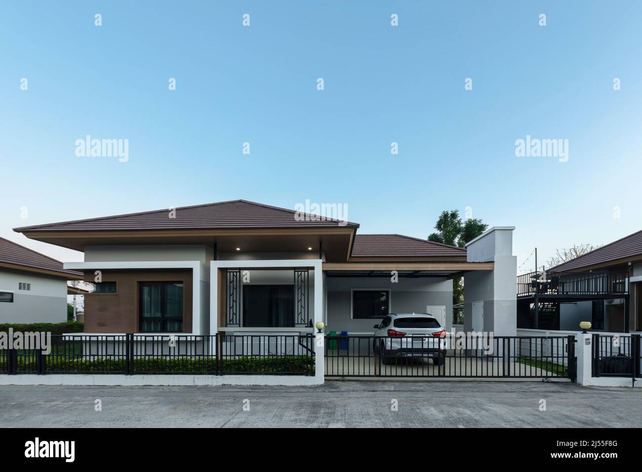Outside view of the house with green fields against clear blue sky