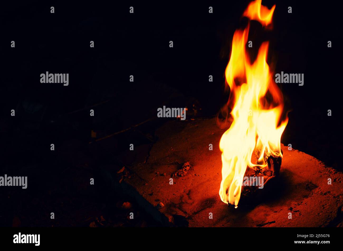 Bright fire torch on dark background. White yellow red flame. Stock Photo