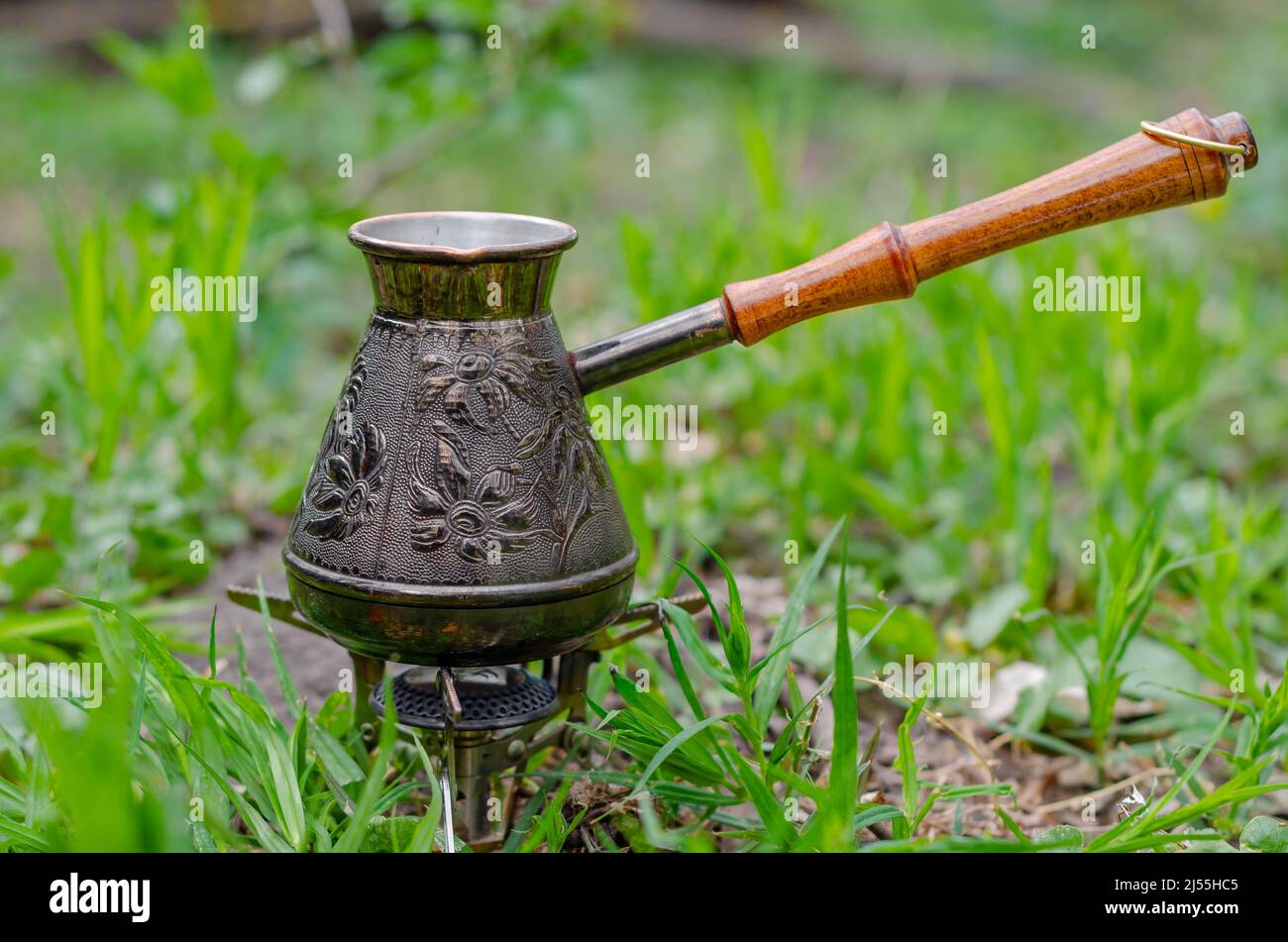 Coffee maker in nature. Turk with coffee on camp gas burner. Rest outside city. Stock Photo