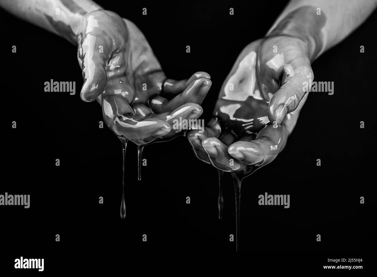 Women's hands in a viscous liquid similar to blood. Black and white